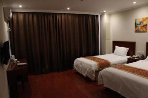 徐州格林豪泰徐州经济开发区大庙镇商务酒店的酒店客房设有两张床和窗户。