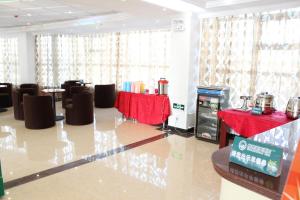新郑贝壳郑州国际机场华夏大道酒店的一间带椅子和桌子的房间以及一张红色的桌布