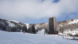 苏佩贝斯Studio-cabine au pied des pistes à Super Besse的雪覆盖滑雪场顶部的建筑物