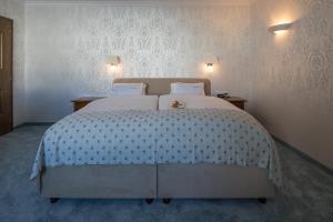 祖尔斯艾伯纳诺瓦酒店的卧室配有一张白色大床,上面有泰迪熊