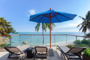 拉迈Royal Beach Boutique Resort & Spa Koh Samui - SHA Extra Plus的庭院配有桌椅和蓝伞。