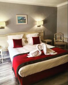 布齐盖蓝色海岸酒店的一间卧室配有一张带红色和白色床单的大床