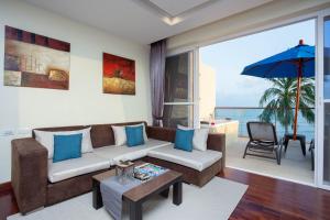 拉迈Royal Beach Boutique Resort & Spa Koh Samui - SHA Extra Plus的带沙发和遮阳伞的客厅