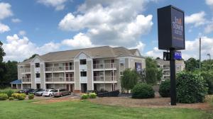 夏洛特Intown Suites Extended Stay Select Charlotte NC - University的前面有标志的大建筑