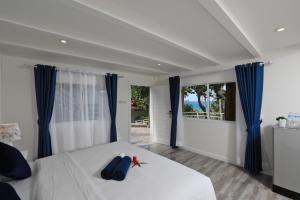 卡塔海滩Kata White Villas的卧室配有一张带蓝色窗帘的大型白色床