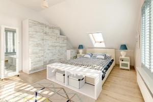 亚斯塔尔尼亚Villa Pastelowa的一间铺有木地板的白色卧室,配有一张床