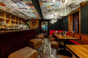 卢森堡格鲁瓦尔德酒店的餐厅设有酒吧,配有桌子和凳子
