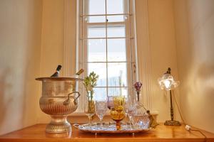开普敦Villa Puccini的窗户上带玻璃杯的桌子