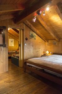 MiazzinaCORTE DI CAVNE'的卧室配有一张床铺,位于带木墙的房间内