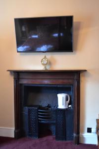 LlangadogThe Red Lion的壁炉上方的电视,上面有咖啡杯