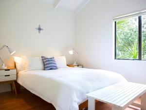 欧尼坦基Two Rooms Onetangi - Onetangi Holiday Home的白色的卧室设有白色的床和窗户。