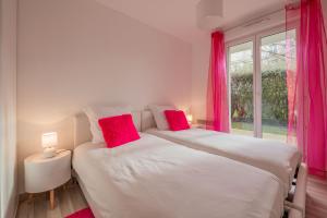 蒙泰夫兰EDEN PARK LUXE DISNEY的一间卧室配有两张带红色枕头的床和窗户。