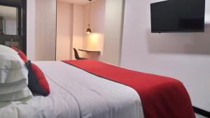 波哥大Hotel WLH Bogota - White Lighthouse的一间卧室配有一张带红白毯子的床