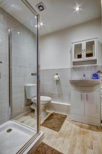 普雷斯蒂克Garden Gate Upper Apartment的带淋浴、卫生间和盥洗盆的浴室