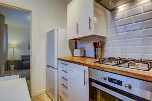 普雷斯蒂克Garden Gate Upper Apartment的厨房配有白色橱柜和炉灶烤箱。