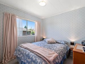 陶波Central Riverside Retreat - Taupo Holiday Home的一间卧室设有一张床和一个窗口