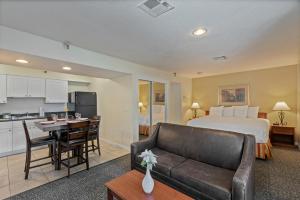 坦帕Chase Suite Hotel Rocky Point Tampa的酒店客房设有床和客厅。