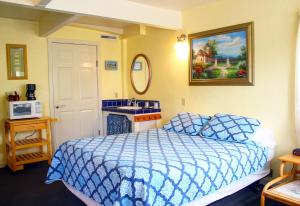 圣克鲁兹海港旅馆的一间卧室配有蓝色的床和水槽