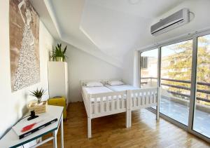 斯科普里Yard Skopje的一间卧室设有两张床、一张桌子和一个窗口。