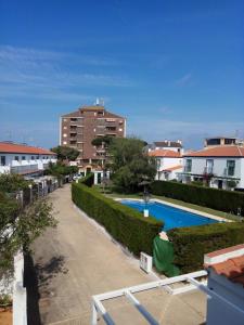 伊斯兰蒂拉islantilla adosado piscina parking 1 minuto al mar的从公寓的阳台可欣赏到游泳池的景色