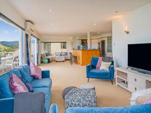 怀蒂昂格Seaview Serenity- Whitianga Holiday Home的客厅配有蓝色的沙发和电视