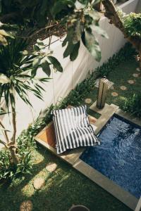 库塔维拉巴厘岛精品酒店及套房的一个带两把椅子的花园和一个游泳池