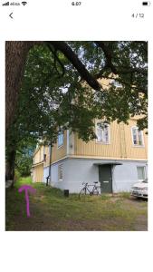 图尔库Puutaloyksiö 1 km Turun rautatieasemalta的前面有粉红箭的房子