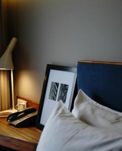 万隆Kollektiv Hotel的一张桌子、一张带照片的床和一部电话