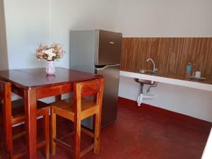 曼巴豪Tongatok Cliff Resort的一间带桌子和冰箱的小厨房
