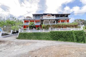 班图尔Adinda Beach Hotel and Villa的一座橙色房子,前面有白色的围栏
