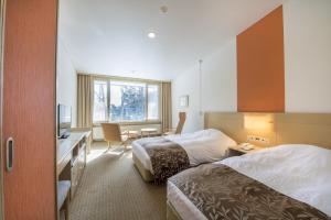 日光Kyukamura Nikko-Yumoto的酒店客房配有两张床和一张书桌