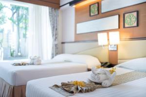 七岩亚洲查安酒店的酒店客房,配有两张带鲜花的床