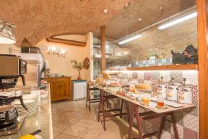 埃尔萨谷口村帕拉佐帕齐尼酒店的厨房配有长桌和食物