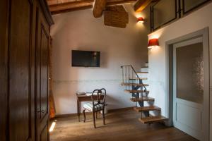 埃尔萨谷口村帕拉佐帕齐尼酒店的楼梯,房间带桌子和椅子