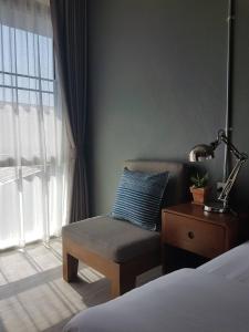 南府Mon-Dee minihotel的卧室配有床、椅子和窗户。