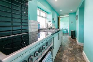 巴姆博格Host & Stay - Daisy Cottage的一间设有蓝色墙壁和水槽的大厨房