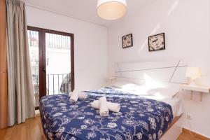 内尔哈Balcon Europa Nerja的卧室配有蓝色和白色的床和窗户。