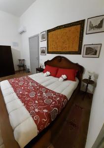 阿塞米尼Villa Iole的一间卧室配有一张带红色枕头的大床