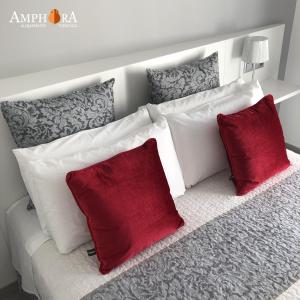 埃希哈Amphora Alojamiento Ecija的一张白色的沙发,上面有两个红色的枕头