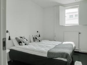 博里霍尔姆Gamla Televerket B&B的白色客房的一张床位,设有窗户