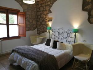 蓬托内斯Casa Rural El Perchel的一间卧室配有一张床、两把椅子和一个浴缸
