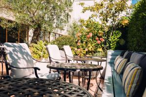 圣赫利尔泽西经典英国泽西俱乐部酒店&SPA的庭院里摆放着几把椅子和桌子