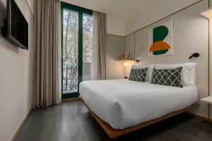 巴塞罗那Be Mate Paseo de Gracia的一间卧室设有一张大床和一个窗户。