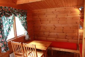 艾于兰Lunde Camping的小木屋内的房间,配有桌椅