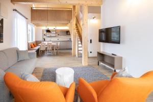 茵特斯托德ALPRIMA Aparthotel Hinterstoder的带沙发和电视的客厅以及厨房。