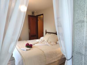 CuntisPensión Pura的一间卧室配有带白色窗帘和鲜花的床