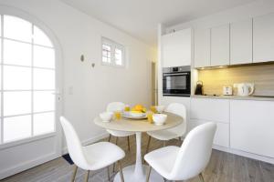 比亚里茨Nice 3 stars flat w beautiful terrace - Biarritz - Welkeys的白色的厨房配有白色的桌子和椅子