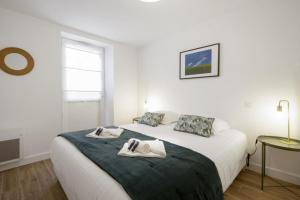 比亚里茨Nice 3 stars flat w beautiful terrace - Biarritz - Welkeys的白色卧室,配有带毛巾的床