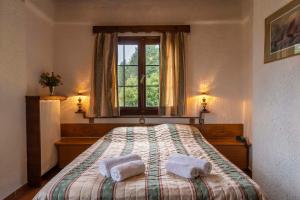 Kréntis马卡斯酒店的一间卧室配有一张床,上面有两条毛巾