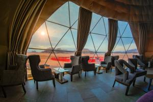 瓦迪拉姆Wadi Rum UFO Luxotel的客房设有桌椅和大窗户。
